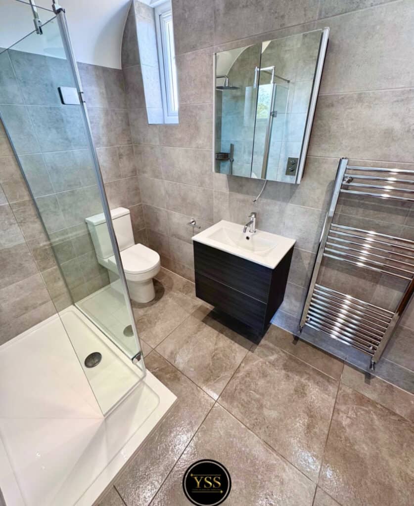 Bright modern bathroom with shower, toilet, vanity, and heated towel rail for home renovation.
