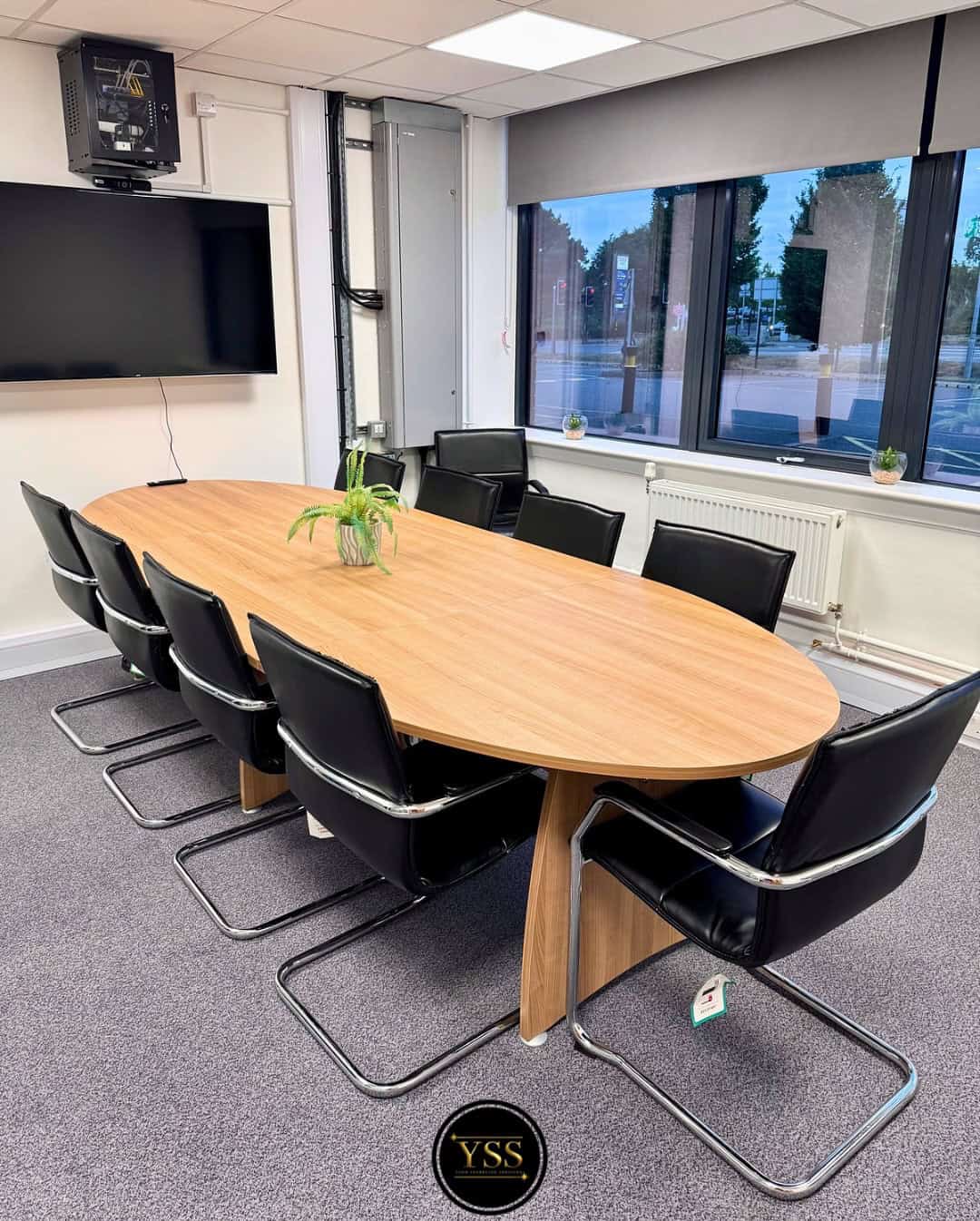 Shiny office meeting room with black leather chairs and large window for professional business space.