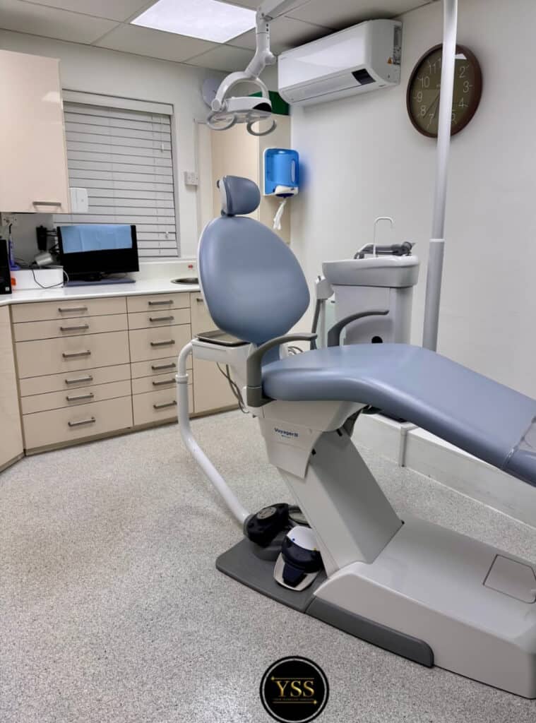 Dentist chair in a clean dental clinic room with modern equipment and tools.