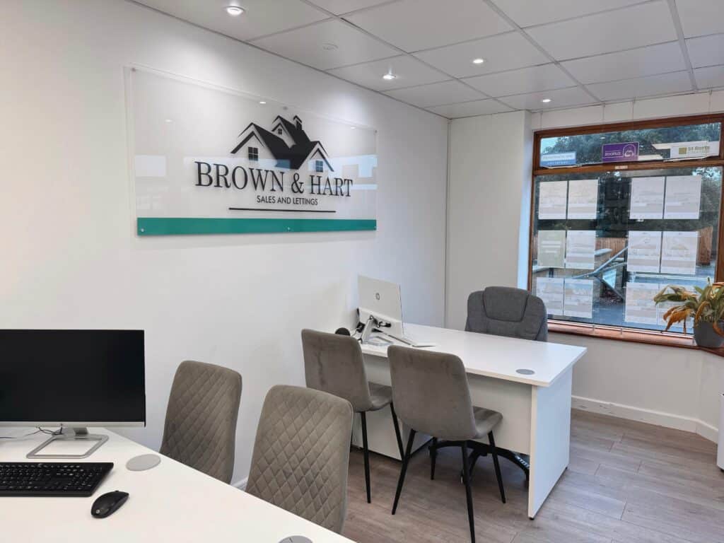 Modern real estate office interior with Brown & Hart signage, sales and lettings, bright lighting, and comfortable seating - Your Sparkling Services Ltd.
