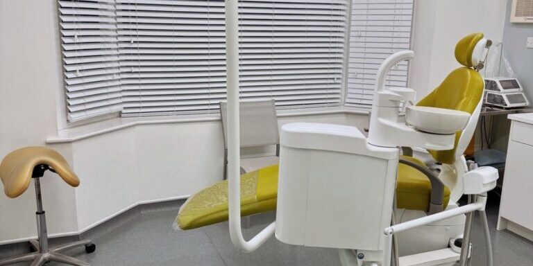 Bright modern dental chair in a clinical setting with cleaning equipment, ensuring hygiene and comfort.
