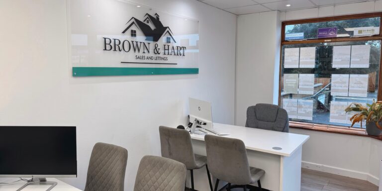 Modern real estate office interior with Brown & Hart signage, sales and lettings, bright lighting, and comfortable seating - Your Sparkling Services Ltd.